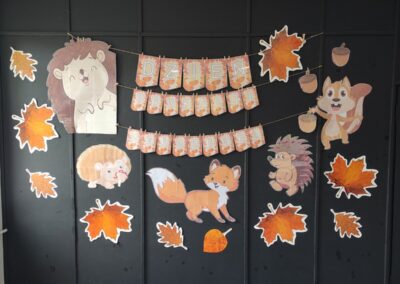 Dekoracja jesienna na Dzień Edukacji Narodowej z lisem, wiewiórką, jeżami i liśćmi.